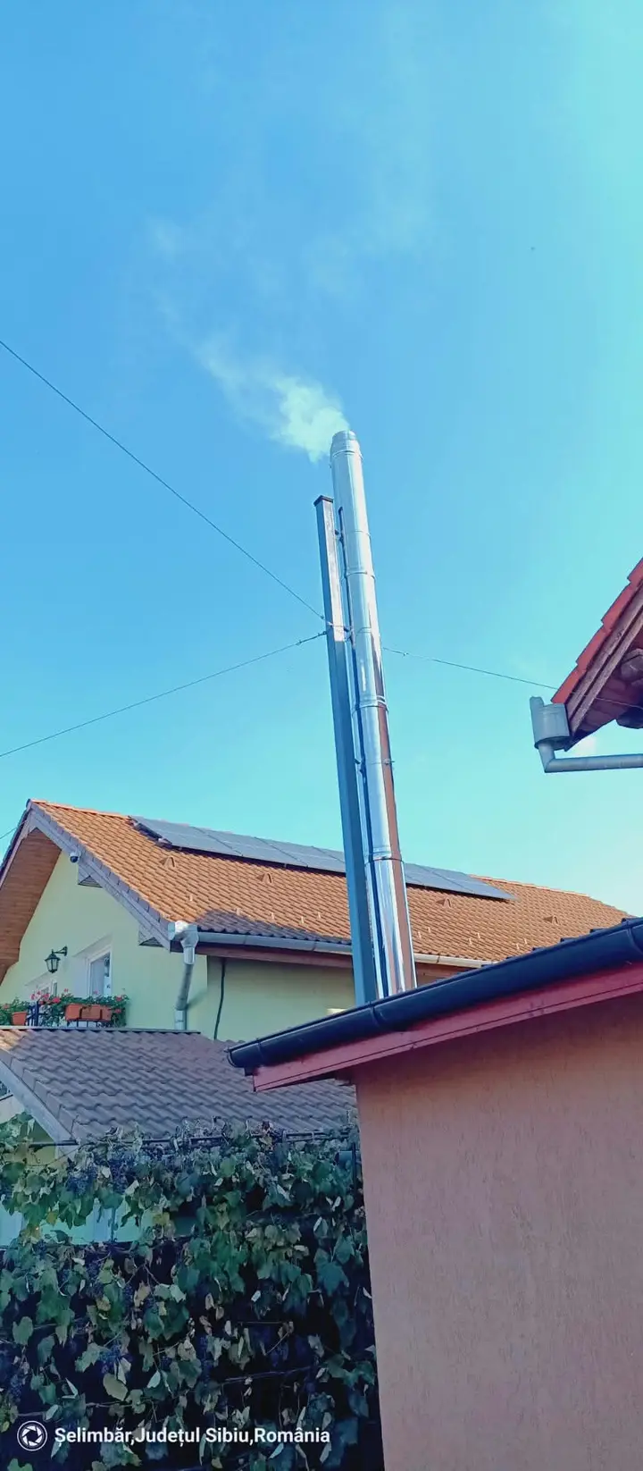 Coș din inox pe un acoperiș, cu fum alb la ieșire