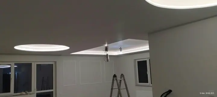 Cameră cu iluminat LED încastrat în tavan și cu ferestre mari