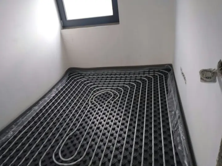 Încălzire în pardoseală montată în buclă într-o cameră cu fereastră în tavan